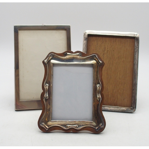 A collection of silver mounted photo frames, including a scrolling