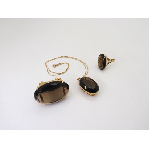 771 - A 14k gold smoky quartz ring, with similar gold plated brooch and pendant, the pendant with a 14k go... 