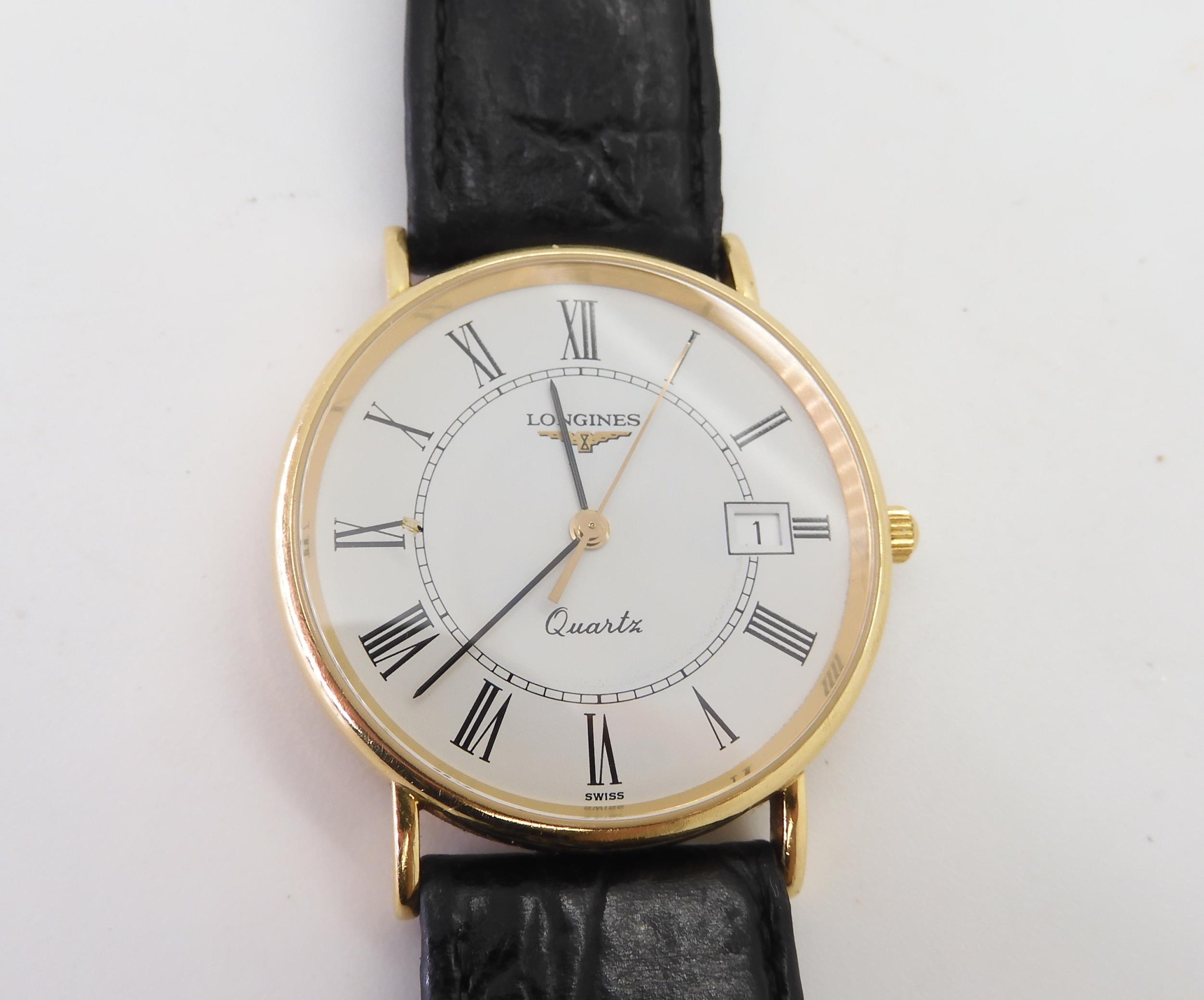 An 18k gold Longines Quartz watch with a black leather strap