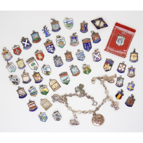 882 - A collection of silver and white metal place name charms, many enamelled a white metal charm bracele... 