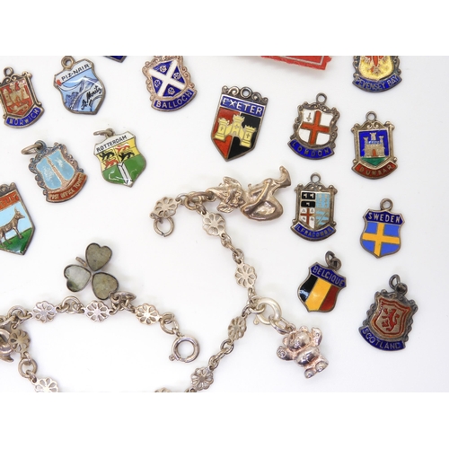 882 - A collection of silver and white metal place name charms, many enamelled a white metal charm bracele... 