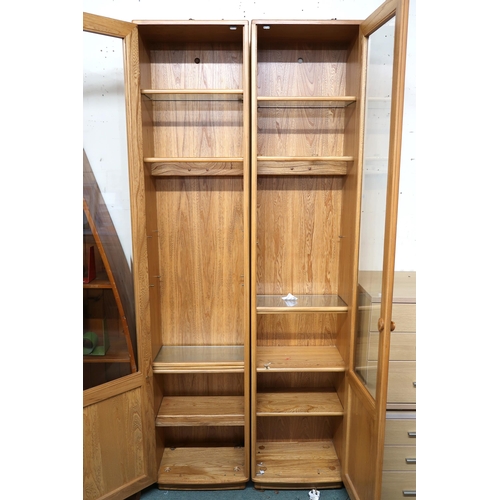 123 - A pair of contemporary Ercol elm and beech glazed tall bookcases, 213cm high x 47cm wide x 31cm deep... 