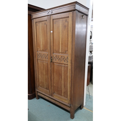 143 - An early 20th century oak Arts and Crafts style two door wardrobe, 195cm high x 111cm wide x 44cm de... 