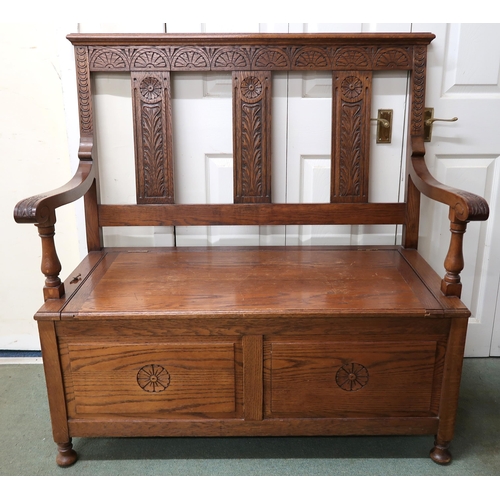 32 - A 20th century oak open hall settle with hinged seat on turned feet, 113cm high x 109cm wide x 57cm ... 