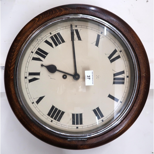 37 - An early 20th century oak cased station style wall clock with white dial bearing Roman numerals, 41c... 
