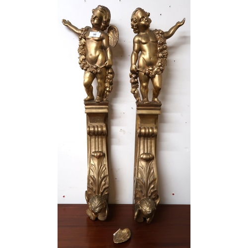 50 - A pair of 20th century gilt gesso scrolled ogee wall mounts capped with figural cherubs, 78cm high (... 