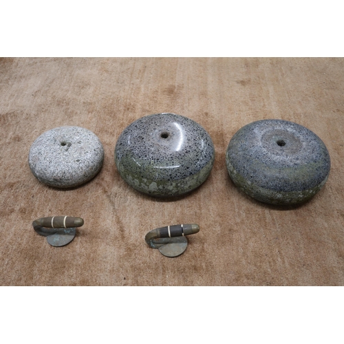 57 - A pair of Scottish polished curling stones with detached handles and another smaller curling stone (... 