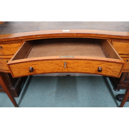 7 - An early 20th century serpentine front writing desk with leather skiver over single long drawer flan... 