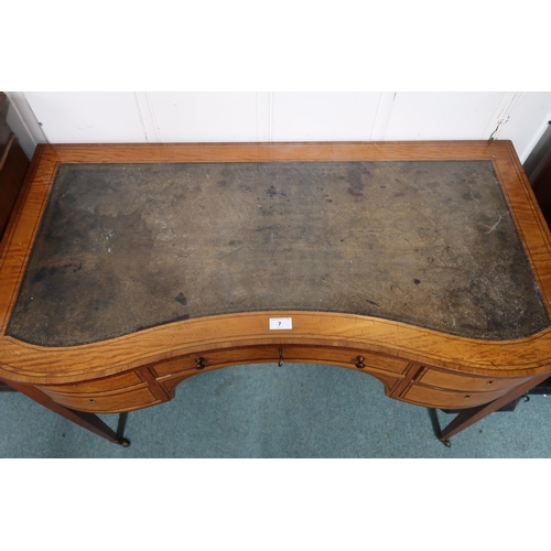 7 - An early 20th century serpentine front writing desk with leather skiver over single long drawer flan... 