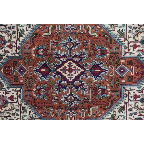 2130 - A CREAM GROUND TABRIZ RUGwith terracotta central medallion, red spandrels and dark blue flower head ... 