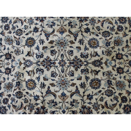 2132 - A CREAM GROUND KASHAN RUGwith all over floral ground and flower head border, 297cm long x 194cm wide... 