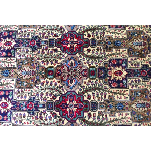 2135 - A CREAM GROUND TABRIZ RUGwith all-over multicoloured floral geometric design and red flower head bor... 