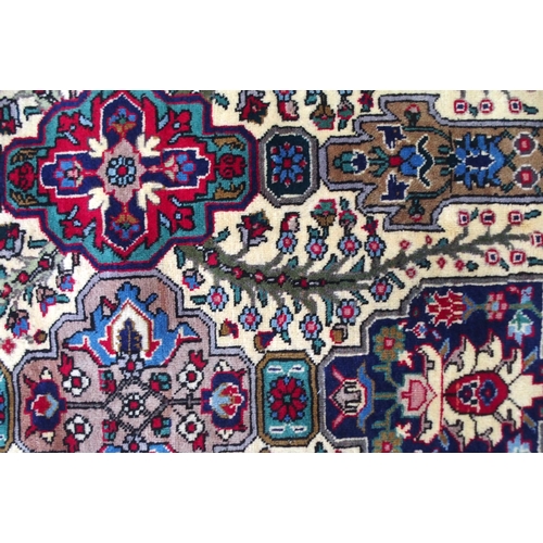 2135 - A CREAM GROUND TABRIZ RUGwith all-over multicoloured floral geometric design and red flower head bor... 