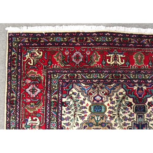 2135 - A CREAM GROUND TABRIZ RUGwith all-over multicoloured floral geometric design and red flower head bor... 