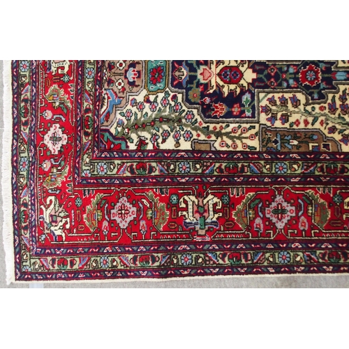 2135 - A CREAM GROUND TABRIZ RUGwith all-over multicoloured floral geometric design and red flower head bor... 