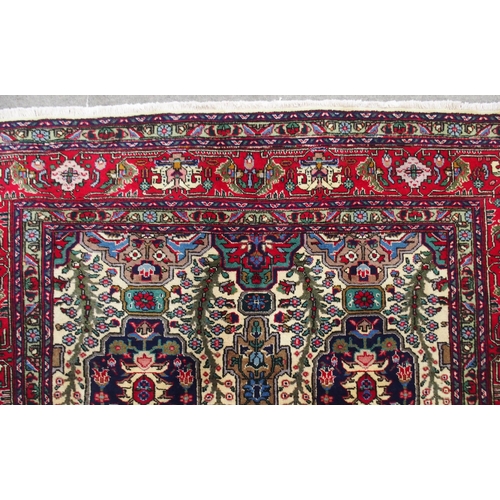 2135 - A CREAM GROUND TABRIZ RUGwith all-over multicoloured floral geometric design and red flower head bor... 