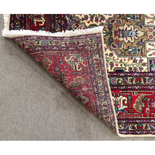 2135 - A CREAM GROUND TABRIZ RUGwith all-over multicoloured floral geometric design and red flower head bor... 