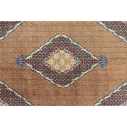 2136 - A COPPER GROUND TABRIZ GROUND RUGwith multicoloured central medallion, matching spandrels and multic... 