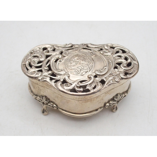 An Art Nouveau silver jewellery box, by Henry Matthews, Birmingham 1903, of shaped form, the lid with  scrolling foliate openwork surrounding a stylised cartouche featuring a maiden in profile, on four stylised pad feet, 118gms