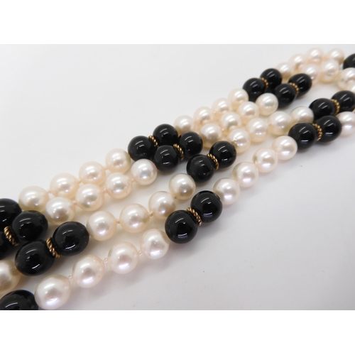 581 - An opera length of good quality pearls, onyx and gold beads, length 88cm