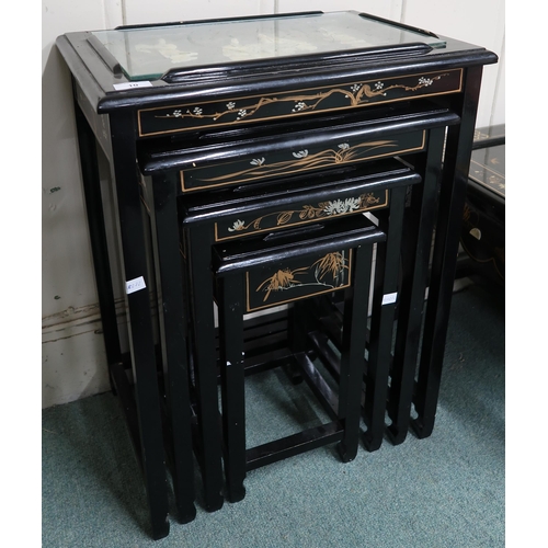 10 - A 20th century Oriental style black lacquered nest of four tables with carved figures under glass to... 