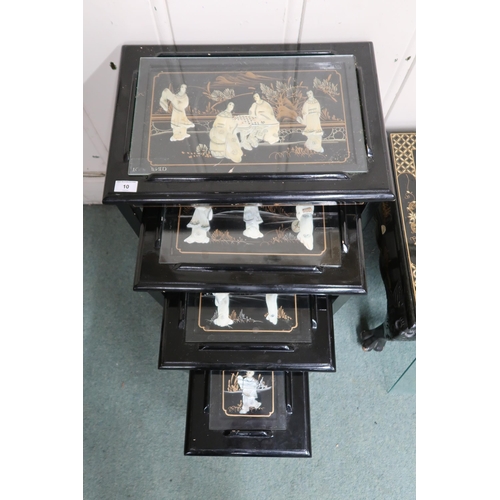 10 - A 20th century Oriental style black lacquered nest of four tables with carved figures under glass to... 