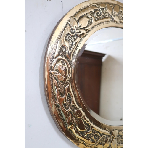 37 - An early 20th century British brass framed oval wall mirror with frame embossed with flowerheads and... 