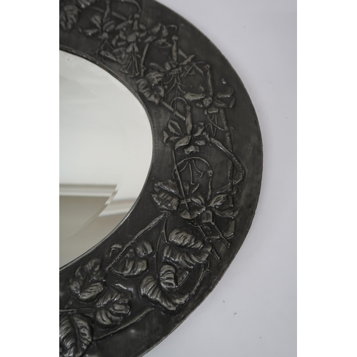 47 - A 20th century British school pewter framed oval wall mirror with embossed foliate design around ova... 