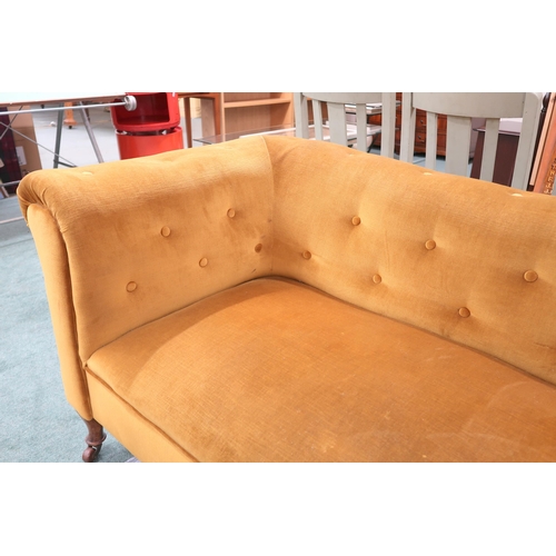 57 - A Victorian mustard button upholstered drop end sofa on shaped supports terminating in ceramic caste... 