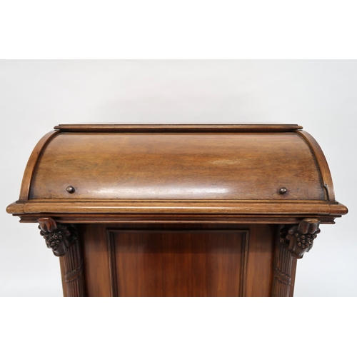 7 - A Victorian mahogany Davenport writing desk with cylinder top writing compartment over pair of carve... 