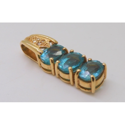 515 - An 18ct gold pendant set with three swimming pool blue apartites and diamond accents, length 3cm, we... 