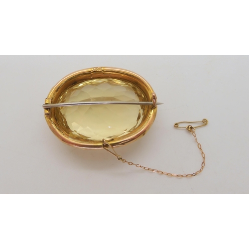 576 - A large citrine brooch, dimensions of the citrine 24mm x 35mm, in a 9ct gold flower engraved frame, ... 