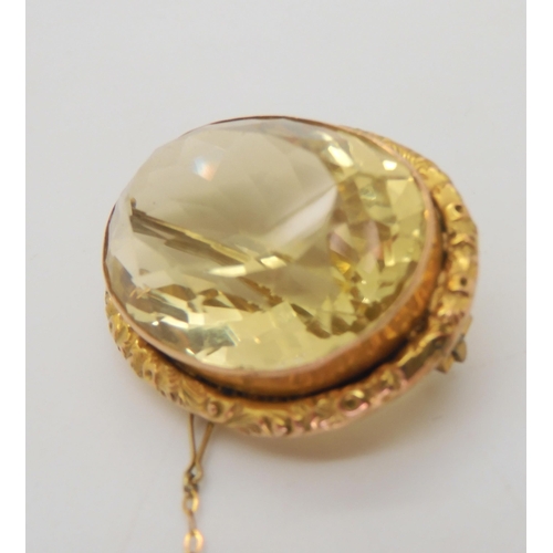 576 - A large citrine brooch, dimensions of the citrine 24mm x 35mm, in a 9ct gold flower engraved frame, ... 