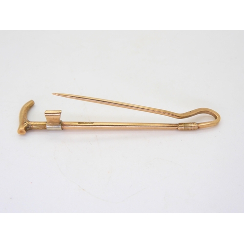 594 - A 9ct gold riding crop brooch made by Joseph Cook & Son, length 5.8cm, together  with a 9ct... 