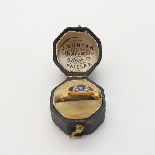 596 - A bright yellow metal ring, set with sapphires and diamonds, inscribed to the inner shank dates 1904... 