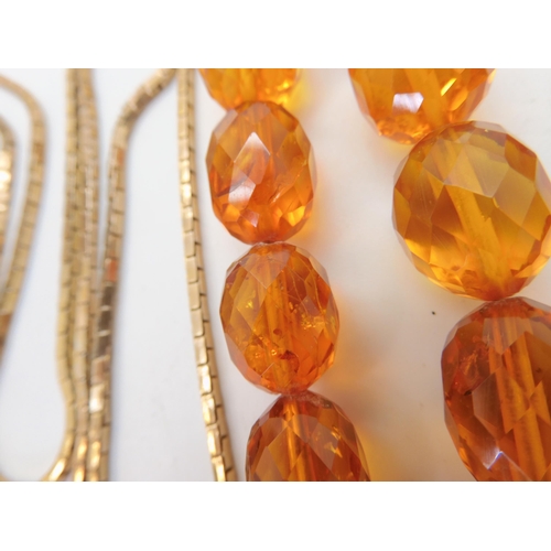 667 - A string of amber coloured beads, weight 94.1gms approx, together with a silver Mackintosh style pen... 