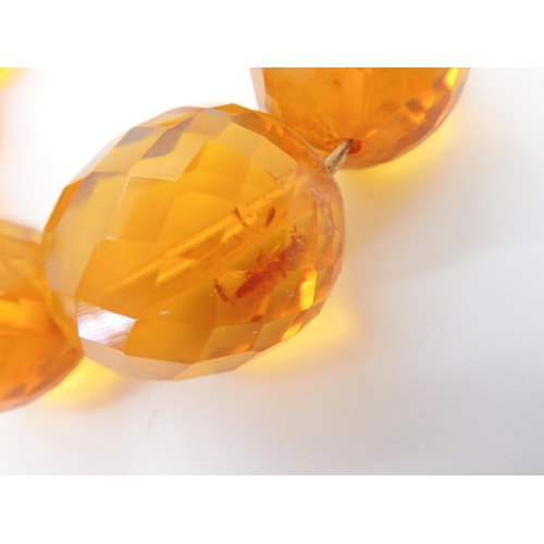 667 - A string of amber coloured beads, weight 94.1gms approx, together with a silver Mackintosh style pen... 