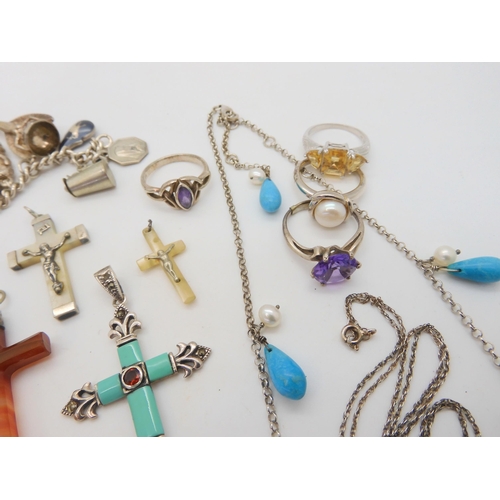 676 - A collection of silver and gemstone crosses, a silver charm bracelet with fifteen silver and white m... 