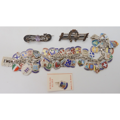 677 - An extensive silver and enamel place name charm bracelet, with two Victorian white metal brooches