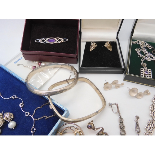 680 - A collection of silver and costume jewellery to include Mackintosh style items, silver bangles, desi... 