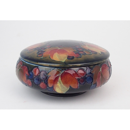 2157 - WILLIAM MOORCROFT A leaves and berries powder pot and cover, 15cm diameter, with impressed and paint... 