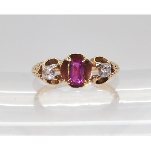 2705 - A VINTAGE THREE STONE RINGset with two old cut diamonds and a mixed cut ruby in a scroll engraved se... 