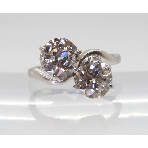 2720 - A SUBSTANTIAL TWIN STONE DIAMOND RINGset with two old cut diamonds with an estimated approx diamond ... 