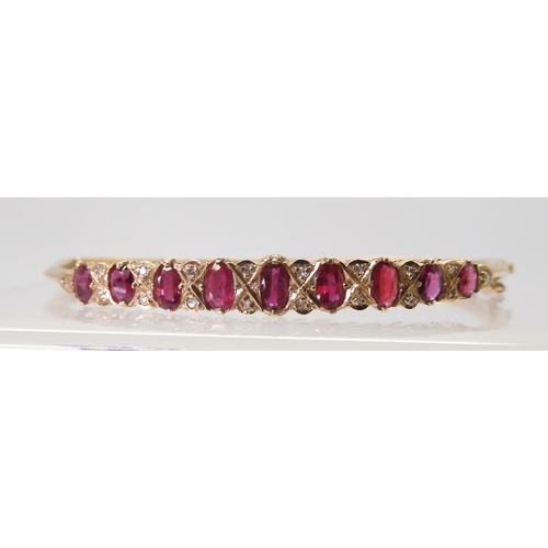 2728 - A 9CT RED GEM & DIAMOND BANGLEwith decorative galleried mount, inner diameter 6.2cm, weight 9.7g... 