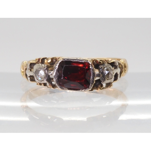 2766 - A GEORGIAN STYLE RINGmounted in yellow metal set with a red gem and rose cut diamonds, finger size a... 