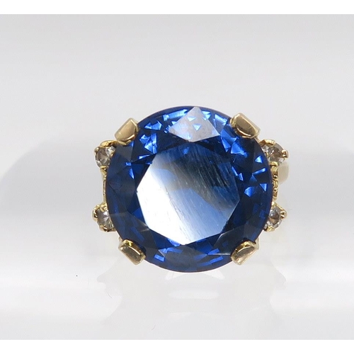 629 - A 10k gold ring set with a large blue and four clear gems, size n, weight 7.5gms