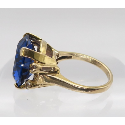 629 - A 10k gold ring set with a large blue and four clear gems, size n, weight 7.5gms