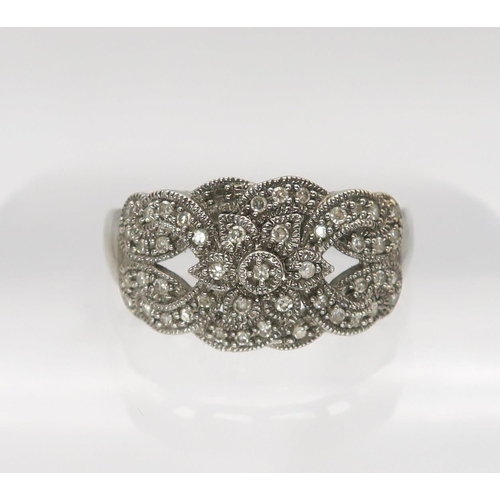 634 - A 9ct white gold diamond accent cluster ring with milgrain setting, finger size T1/2, weight 4.9gms