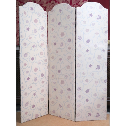 102 - A contemporary three panelled room divider upholstered in floral cream fabric with studded edges, 15... 