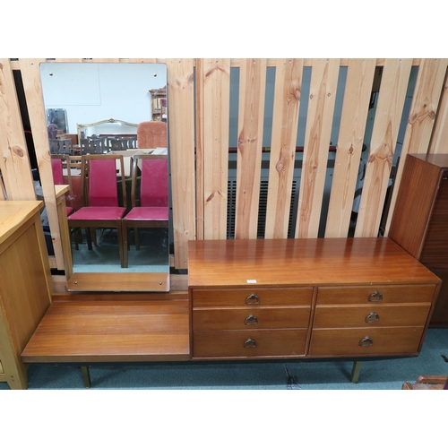 114 - A mid 20th century teak mirror backed dressing table with mirror offset from three pairs of graduati... 